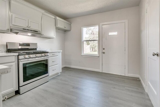 941 SW 48th St, Oklahoma City, OK 73109 - kitchen with stainless steel gas range, under cabinet range hood, light wood-style flooring, light countertops, and a textured ceiling