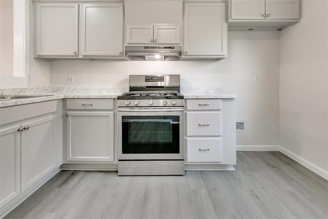 941 SW 48th St, Oklahoma City, OK 73109 - kitchen featuring stainless steel range with gas stovetop, ventilation hood, light wood finished floors, baseboards, and light stone countertops