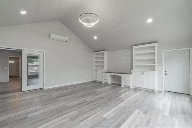unfurnished living room with built in desk, recessed lighting, baseboards, lofted ceiling, and light wood-type flooring