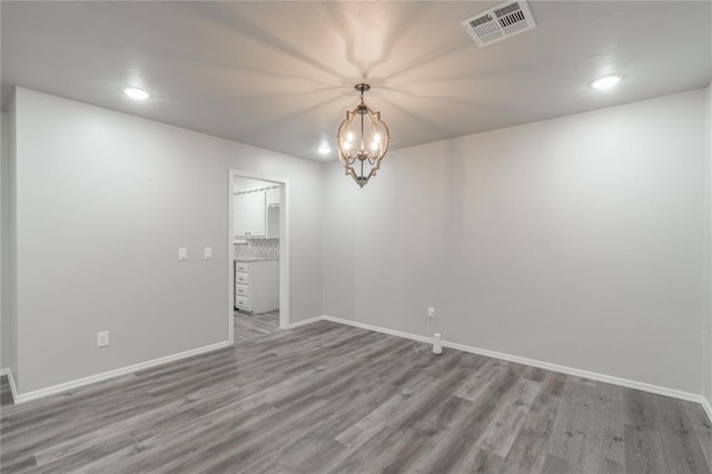 empty room with baseboards, visible vents, and wood finished floors