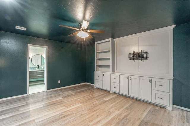 interior space featuring baseboards, visible vents, a sink, and light wood-style floors