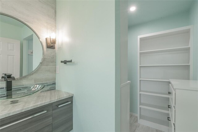 bathroom featuring vanity and tasteful backsplash