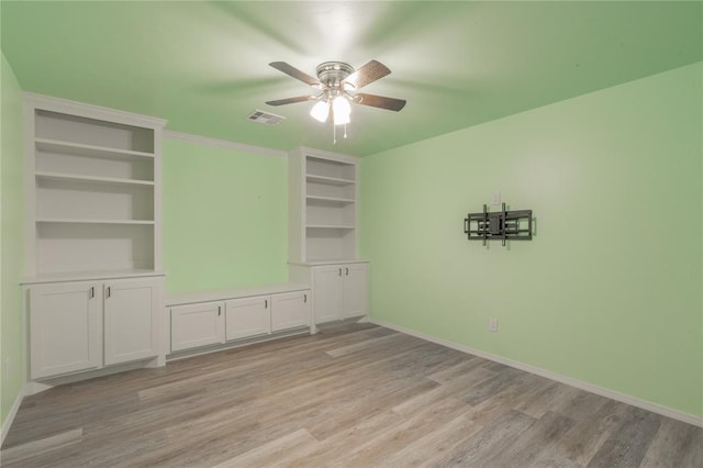 unfurnished room with baseboards, a ceiling fan, light wood-style flooring, and visible vents