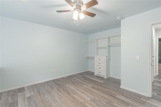 unfurnished bedroom featuring baseboards, light wood finished floors, ceiling fan, and a closet