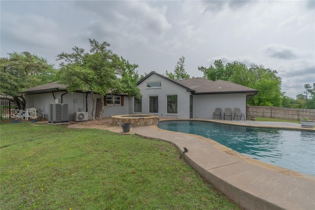 view of pool featuring central AC, a lawn, fence, and a pool with connected hot tub