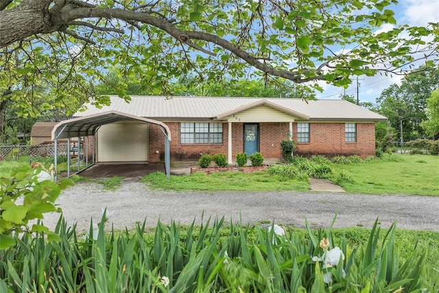 ranch-style house with a front yard, dirt driveway, a carport, brick siding, and fence