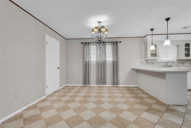 interior space with a chandelier, visible vents, a textured ceiling, and baseboards