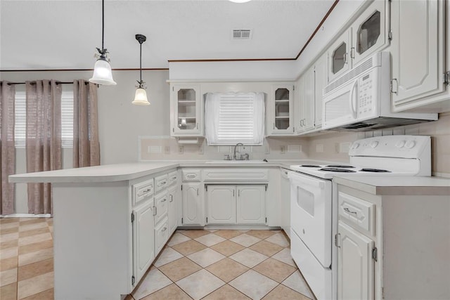 kitchen with glass insert cabinets, a sink, visible vents, white appliances, and a peninsula