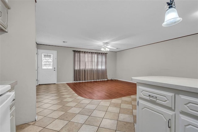 unfurnished living room featuring light tile patterned floors and a ceiling fan
