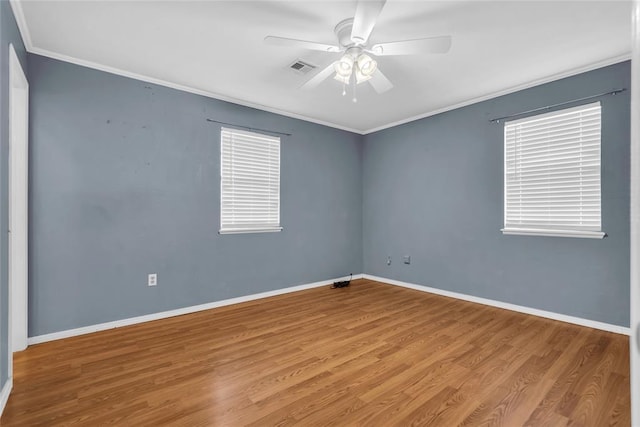 unfurnished room featuring wood finished floors, baseboards, visible vents, a ceiling fan, and crown molding
