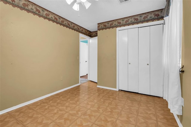 unfurnished bedroom with light floors, a closet, ceiling fan, baseboards, and visible vents