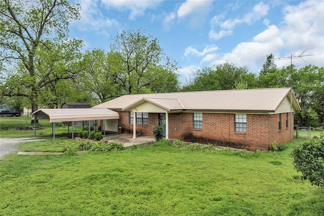 view of front of house with a front lawn, dirt driveway, brick siding, and a carport