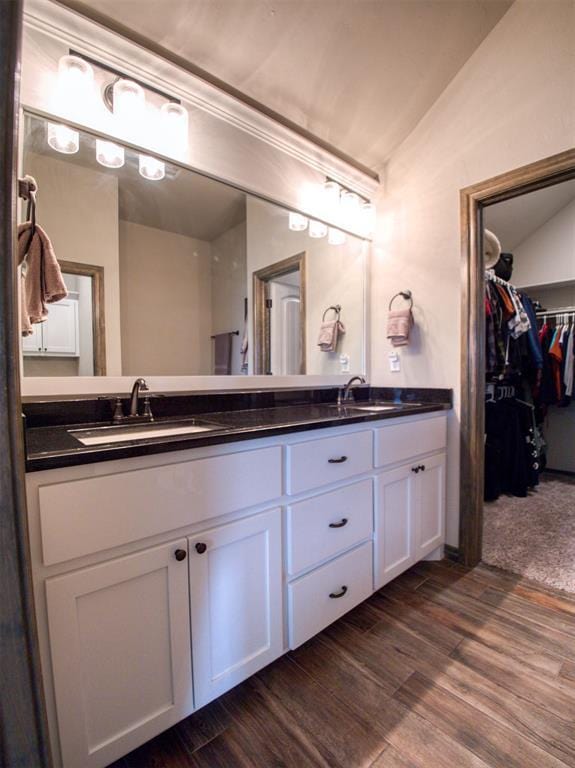 2216 Wheatheart Dr, Yukon, OK 73099 - bathroom featuring double vanity, vaulted ceiling, wood finished floors, and a sink