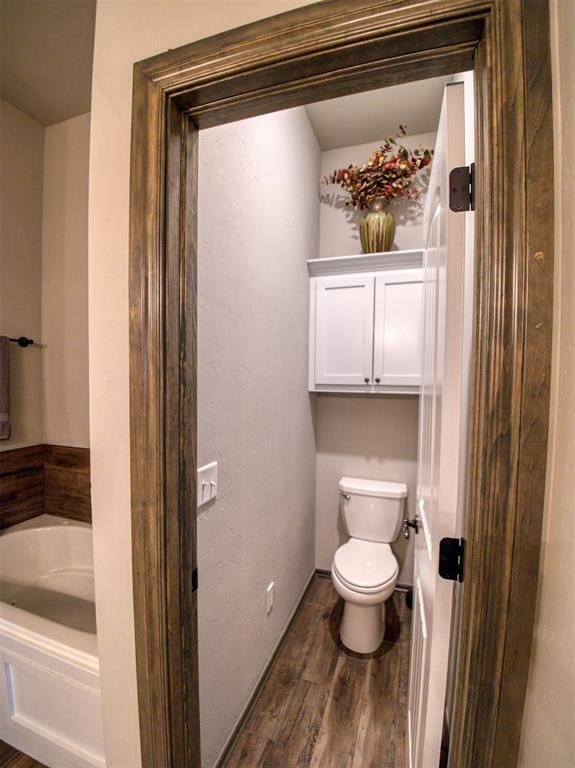 2216 Wheatheart Dr, Yukon, OK 73099 - bathroom with a garden tub, toilet, and wood finished floors