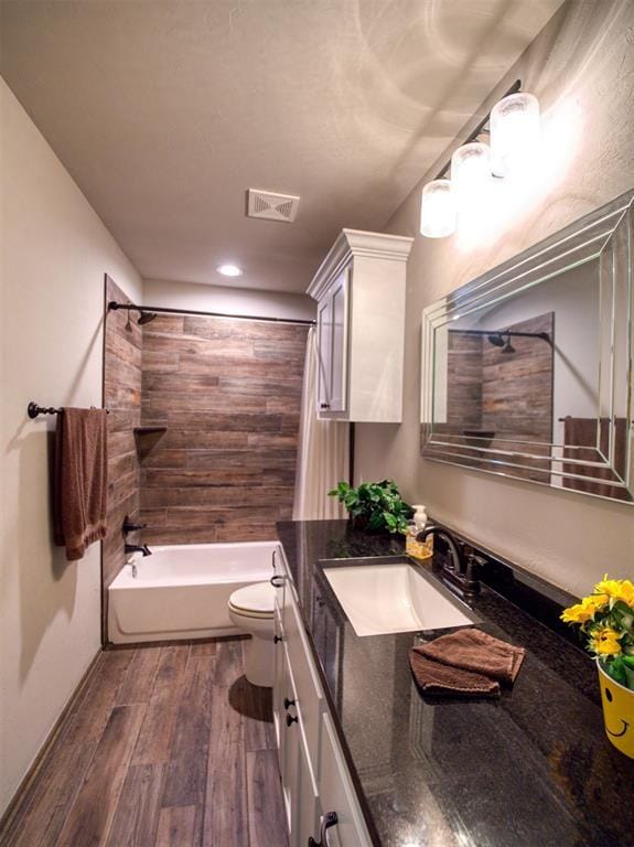 2216 Wheatheart Dr, Yukon, OK 73099 - bathroom with toilet,  shower combination, visible vents, vanity, and wood finished floors