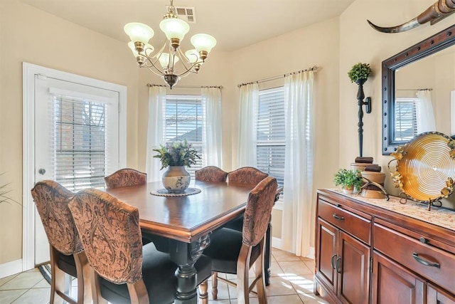 dining area with light tile patterned flooring, baseboards, an inviting chandelier, and visible vents