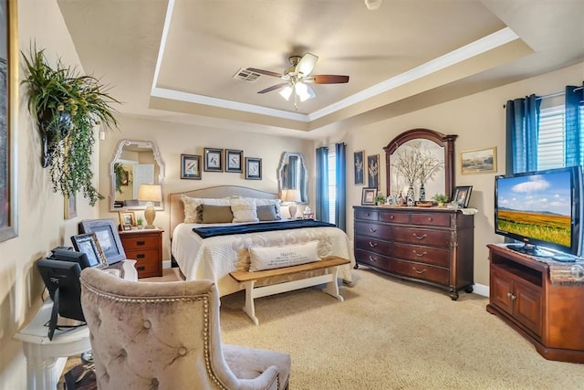 bedroom with ceiling fan, light carpet, baseboards, a tray ceiling, and visible vents