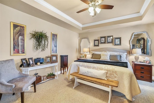 bedroom with a raised ceiling, carpet, and a ceiling fan