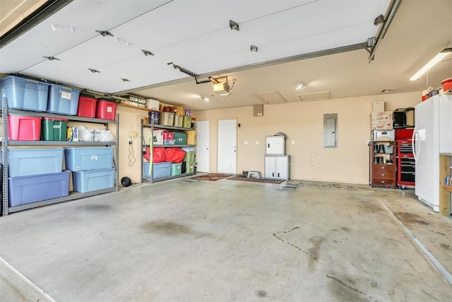 garage with a garage door opener and electric panel