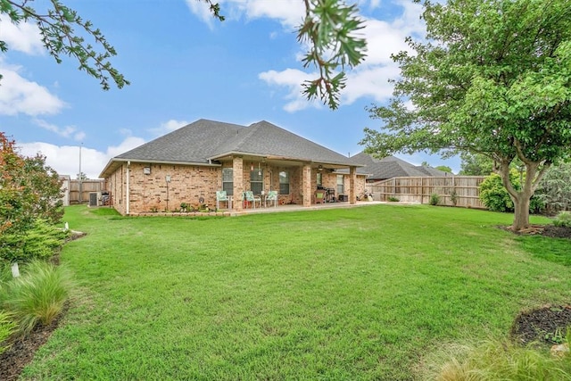 back of house featuring a fenced backyard, ceiling fan, and a lawn