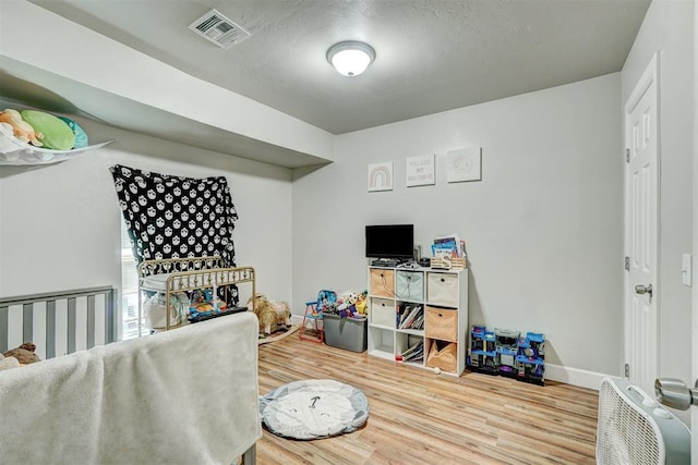game room featuring baseboards, wood finished floors, and visible vents