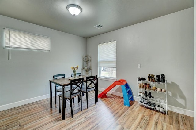 rec room with baseboards, visible vents, and wood finished floors