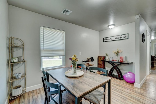 dining room with baseboards, visible vents, and light wood-style floors