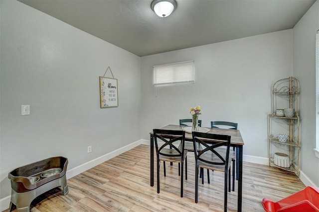 dining room with baseboards and light wood finished floors