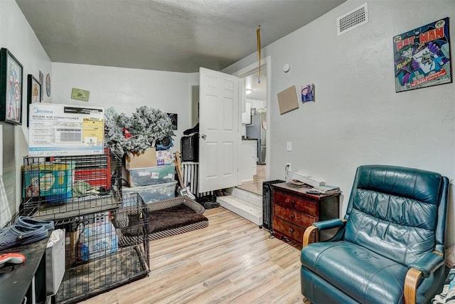 sitting room featuring visible vents and wood finished floors