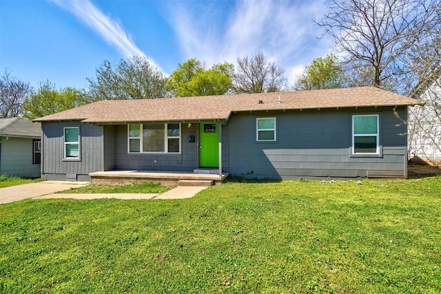 single story home with a porch, a shingled roof, and a front lawn