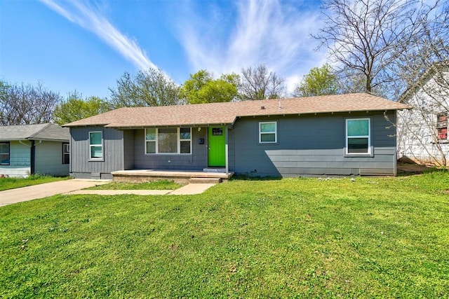 ranch-style house with covered porch, roof with shingles, and a front yard