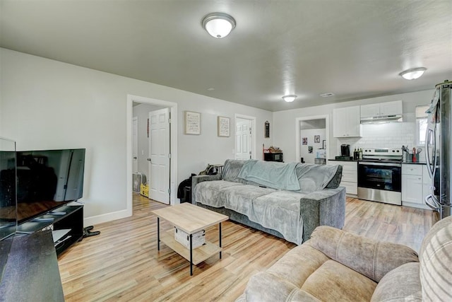 living area featuring baseboards and light wood-style flooring