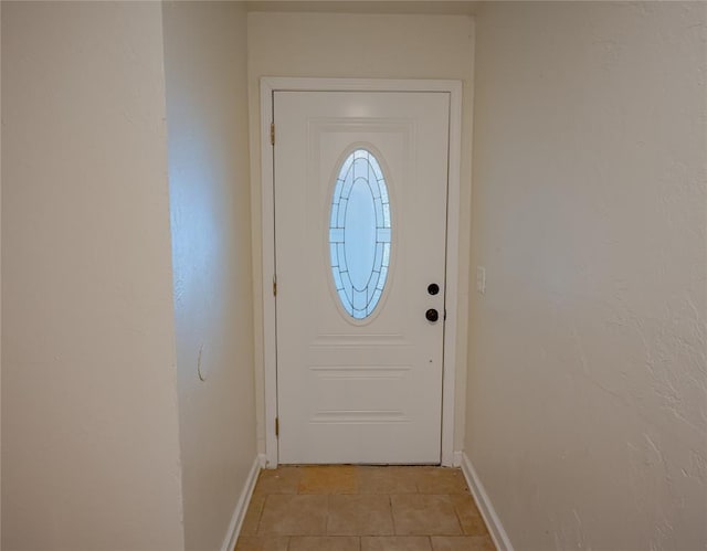 entryway with baseboards and light tile patterned floors