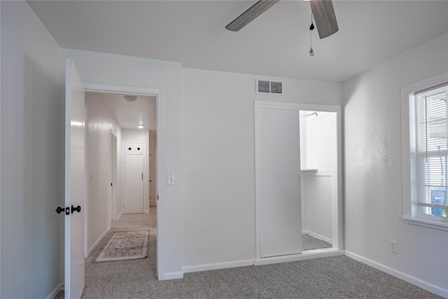 unfurnished bedroom featuring carpet, visible vents, ceiling fan, and baseboards