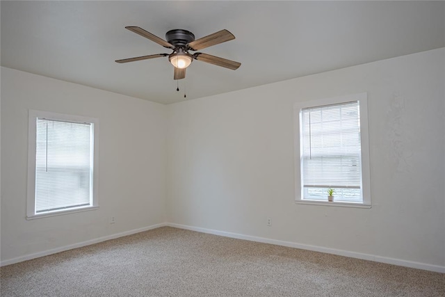 carpeted empty room featuring baseboards and ceiling fan