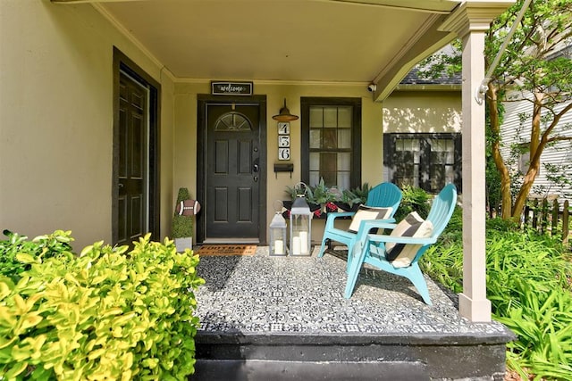doorway to property with a porch and stucco siding