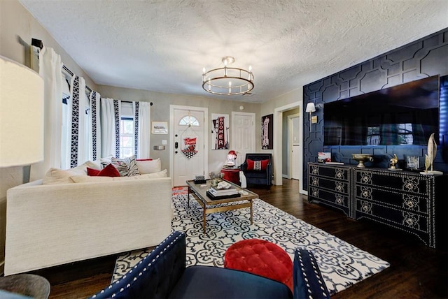 living area featuring a textured ceiling, a notable chandelier, and wood finished floors