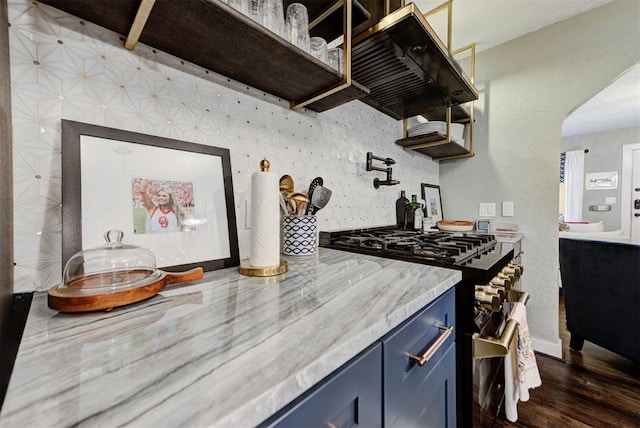 kitchen featuring backsplash, high end stainless steel range oven, dark wood finished floors, and blue cabinetry