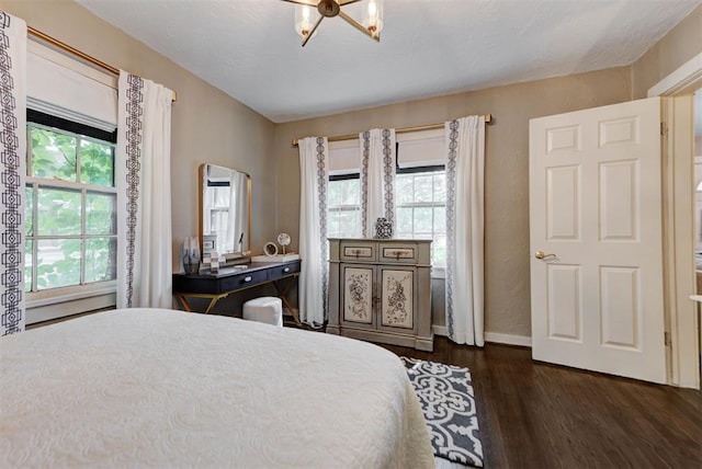 bedroom with baseboards and dark wood finished floors