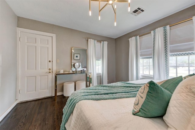 bedroom featuring baseboards, visible vents, and wood finished floors
