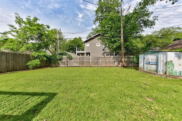 view of yard with a storage shed, an outdoor structure, and a fenced backyard