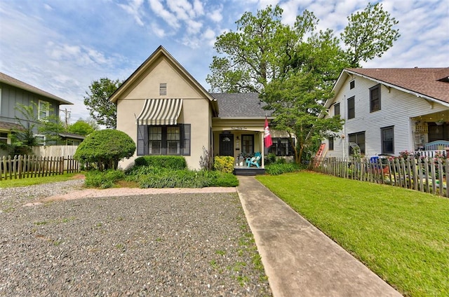 view of front facade featuring stucco siding, fence, and a front yard