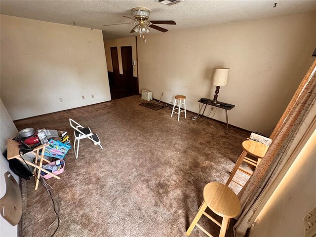 interior space with carpet floors, a ceiling fan, a textured ceiling, and visible vents