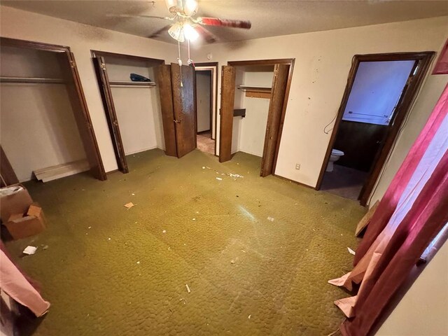 unfurnished bedroom featuring carpet floors, baseboards, and multiple closets