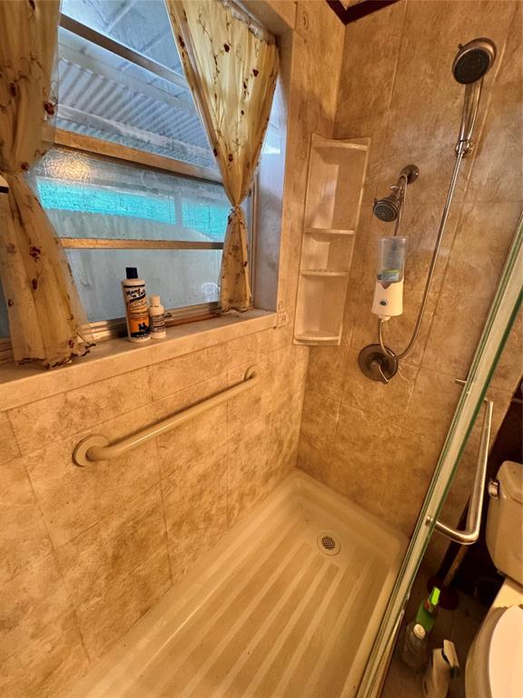 full bathroom with a stall shower and toilet