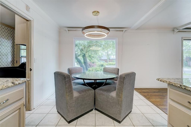 dining room featuring light tile patterned flooring and beamed ceiling