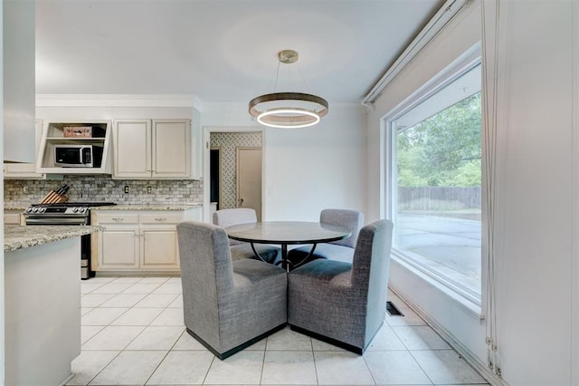 dining area featuring crown molding and light tile patterned flooring