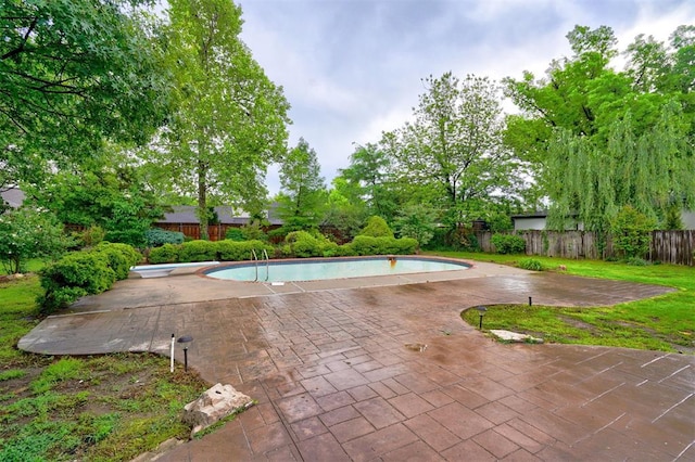 view of swimming pool featuring a diving board, fence, a patio area, and a fenced in pool