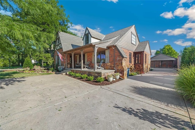 1119 Glenwood Ave, Nichols Hills, OK 73116 - view of property exterior featuring a porch, a shingled roof, and brick siding