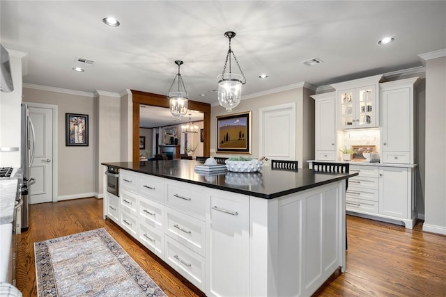 1119 Glenwood Ave, Nichols Hills, OK 73116 - kitchen with a chandelier, white cabinets, ornamental molding, dark countertops, and visible vents
